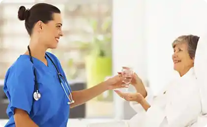 industries-health-care nurse giving glass of water to patient